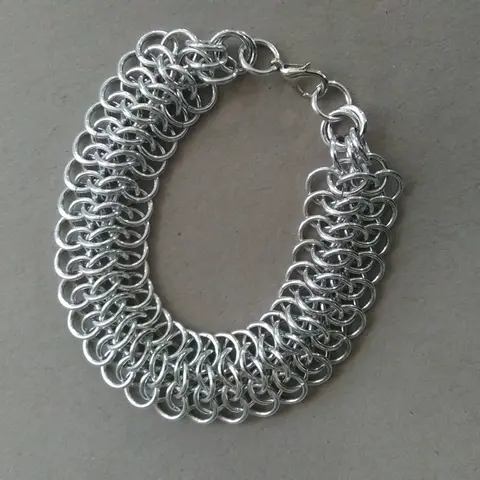 Bright silver aluminum chain mail bracelet on a grey background.