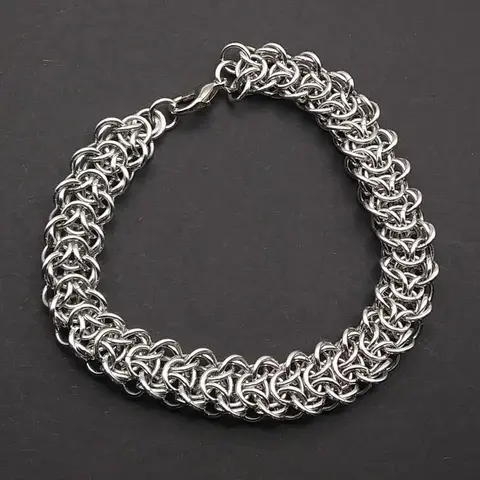 Bright silver aluminum chain mail bracelet on a dark grey background.