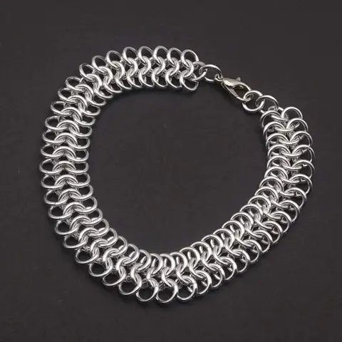 Bright silver aluminum chain mail bracelet on a dark grey background.