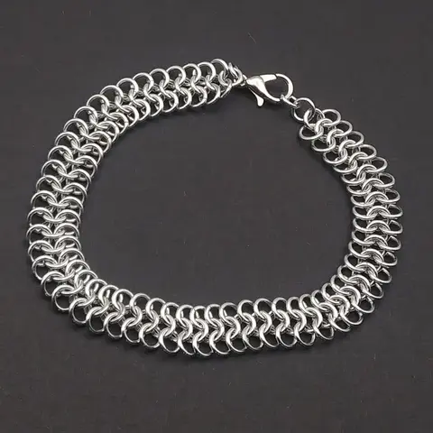 Bright silver aluminum chain mail bracelet on a dark grey background.