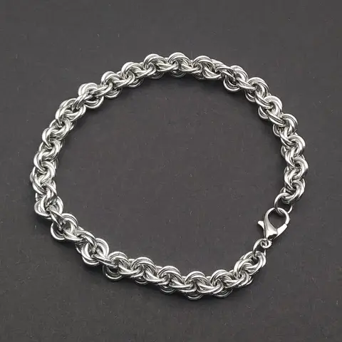 Bright silver aluminum chain mail bracelet on a dark grey background.