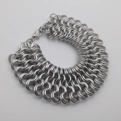 Silver chain mail bracelet laying on a white background