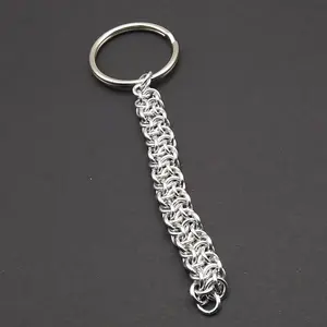 Bright silver aluminum chain mail keychain on a dark grey background.