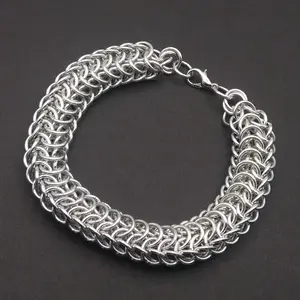 Bright silver aluminum chain mail bracelet on a dark grey background.