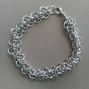 Bright silver aluminum chain mail bracelet on a grey background.