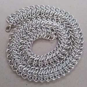 Bright silver aluminum chain mail necklace on a grey background.