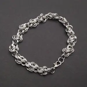 Bright silver aluminum chain mail bracelet on a dark grey background.