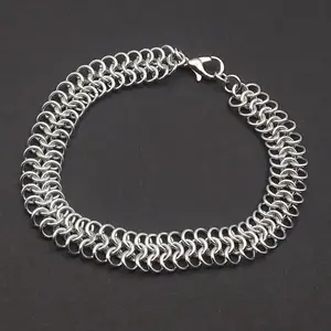 Bright silver aluminum chain mail bracelet on a dark grey background.