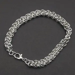 Bright silver aluminum chain mail bracelet on a dark grey background.